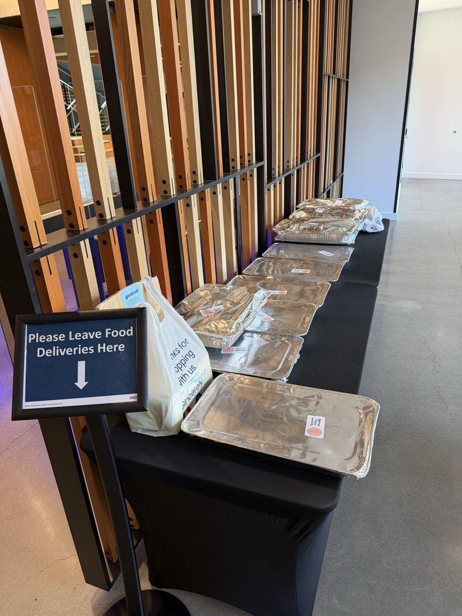 Foil catering trays delivered and set up on a draped table in a Seattle office lobby
