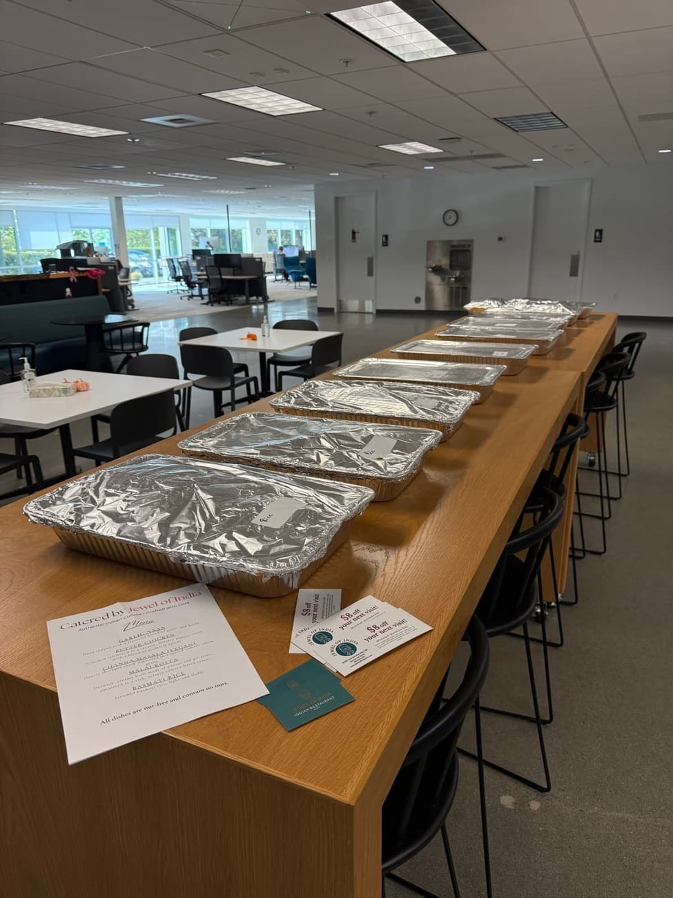 Jewel of India catering delivered and set up with labeled foil trays and a printed menu at a Seattle corporate office